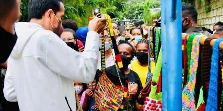 Presiden Joko Widodo (Jokowi) mengunjungi Papua untuk menghadiri pembukaan gelaran PON XX Papua yang akan digelar Sabtu (2/10/2021). Setibanya di Sentani Papua, Jokowi menyempatkan untuk beli tas noken di pinggir jalan. (Foto Ist)